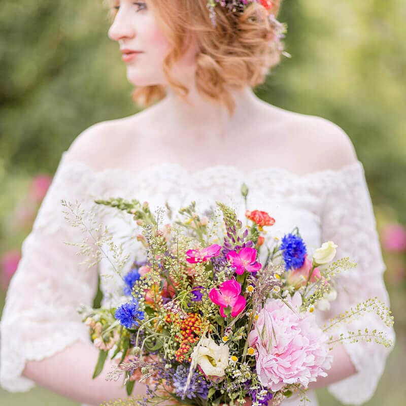 Braut mit Wildblumen Brautstrauß und roten Locken