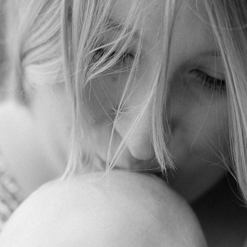 Schwarz Weiß Foto: Mutter küsst Baby auf den Kopf