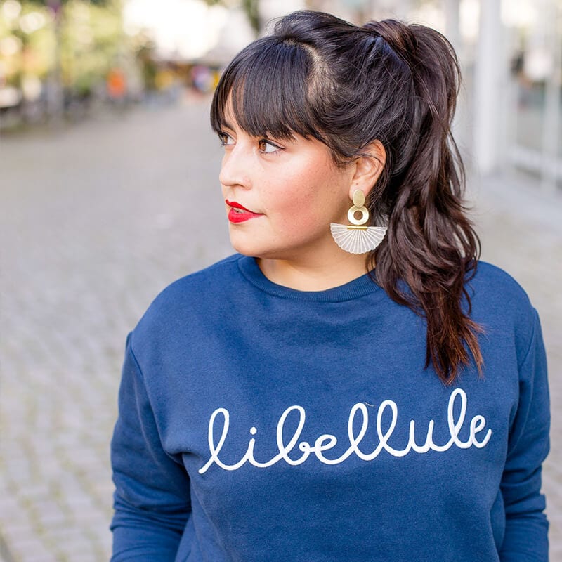 Frau mit blauem Pullover und braunen Haaren schaut nach links