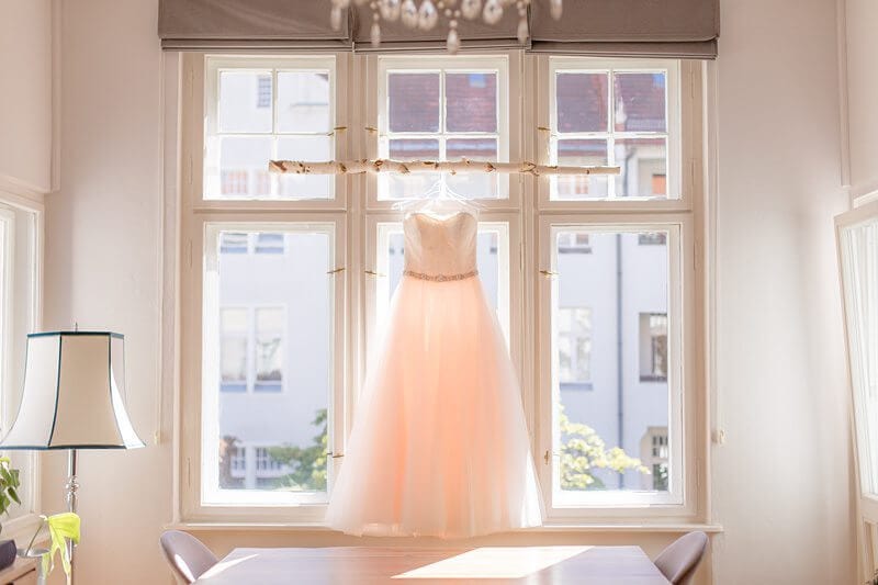 Brautkleid hängt vor Fenster