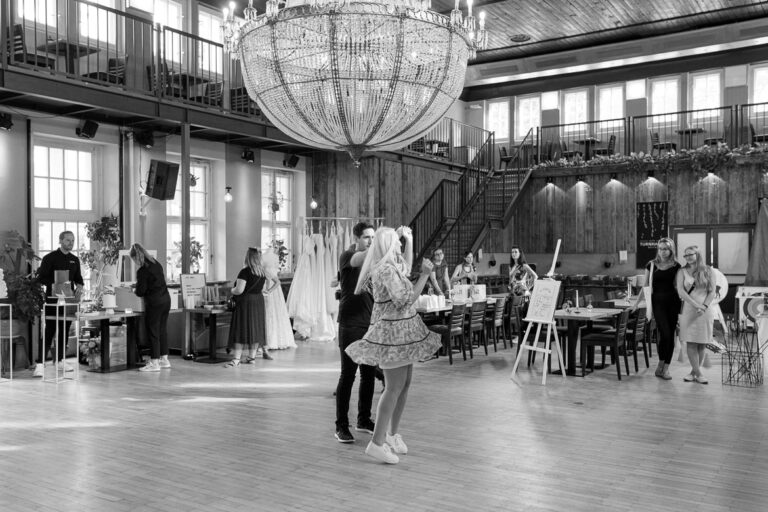 Ein Paar in Sommerkleidern tanzt in einer alten Turnhalle eine einstudierte Hochzeitstanz Choreografie