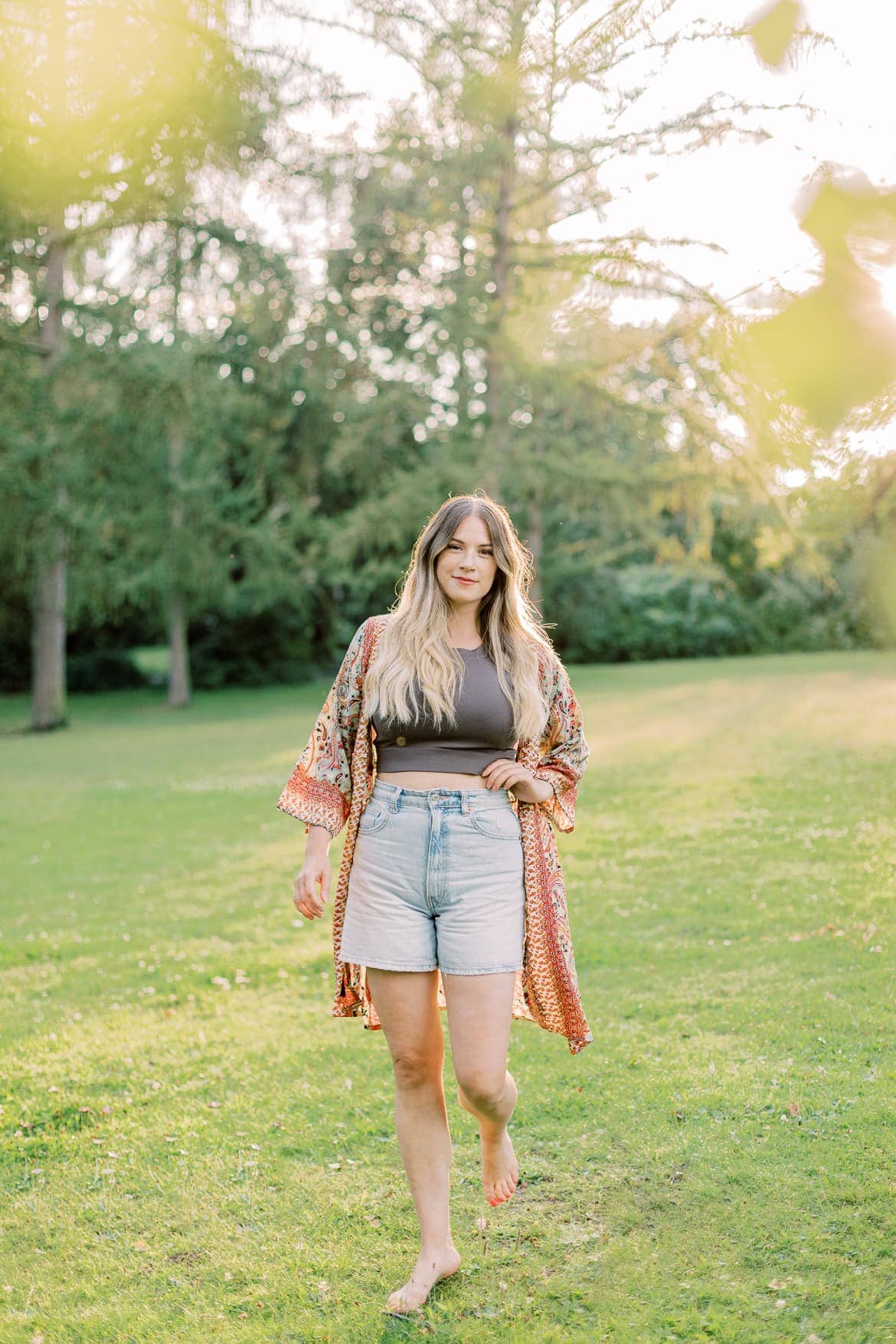 Frau mit blonden Haaren und Kimono in der Abendsonne im Park