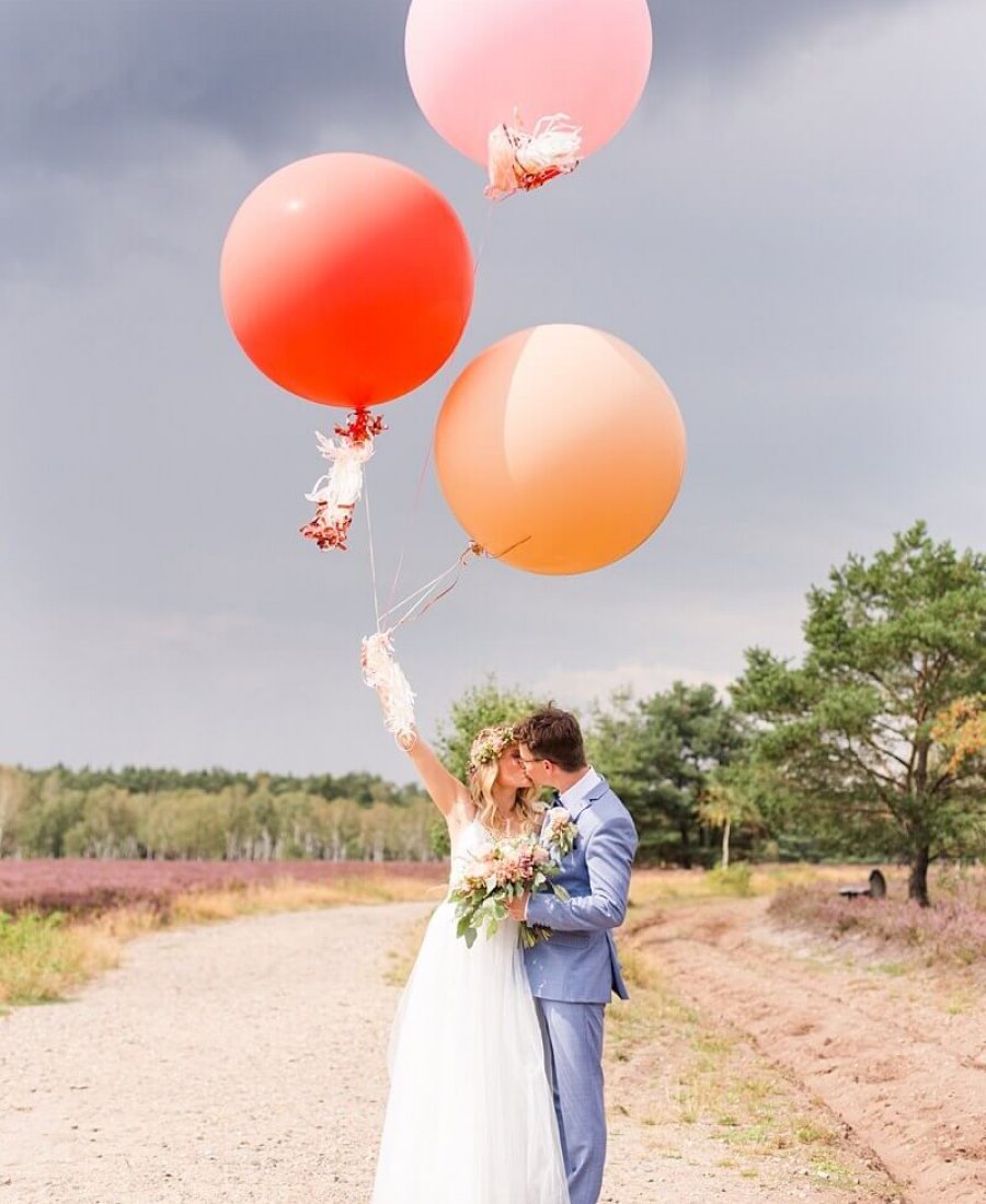 Hochzeitsfotograf Berlin Brautpaar mit drei großen Luftballons in der Lüneburger Heide
