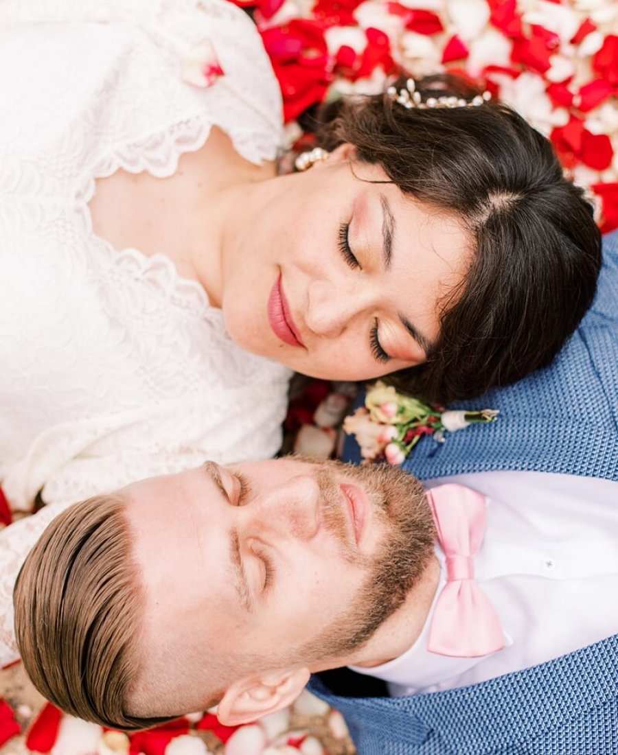 hochzeitsfotograf-berlin_kundenstimmen038 Hochzeitspaar liegt auf Rosenblättern