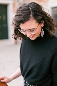 Berliner Hochzeitsfotografin Frau im schwarzen Pullover lacht nach unten